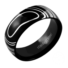 Load image into Gallery viewer, A black stainless steel ring with a white marble-like design, polished finish, and rounded edges.
