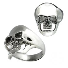 Load image into Gallery viewer, A stainless steel skull ring shown from two angles on a plain white background, with one view showing the front of the skull and the other showing the side and band.

